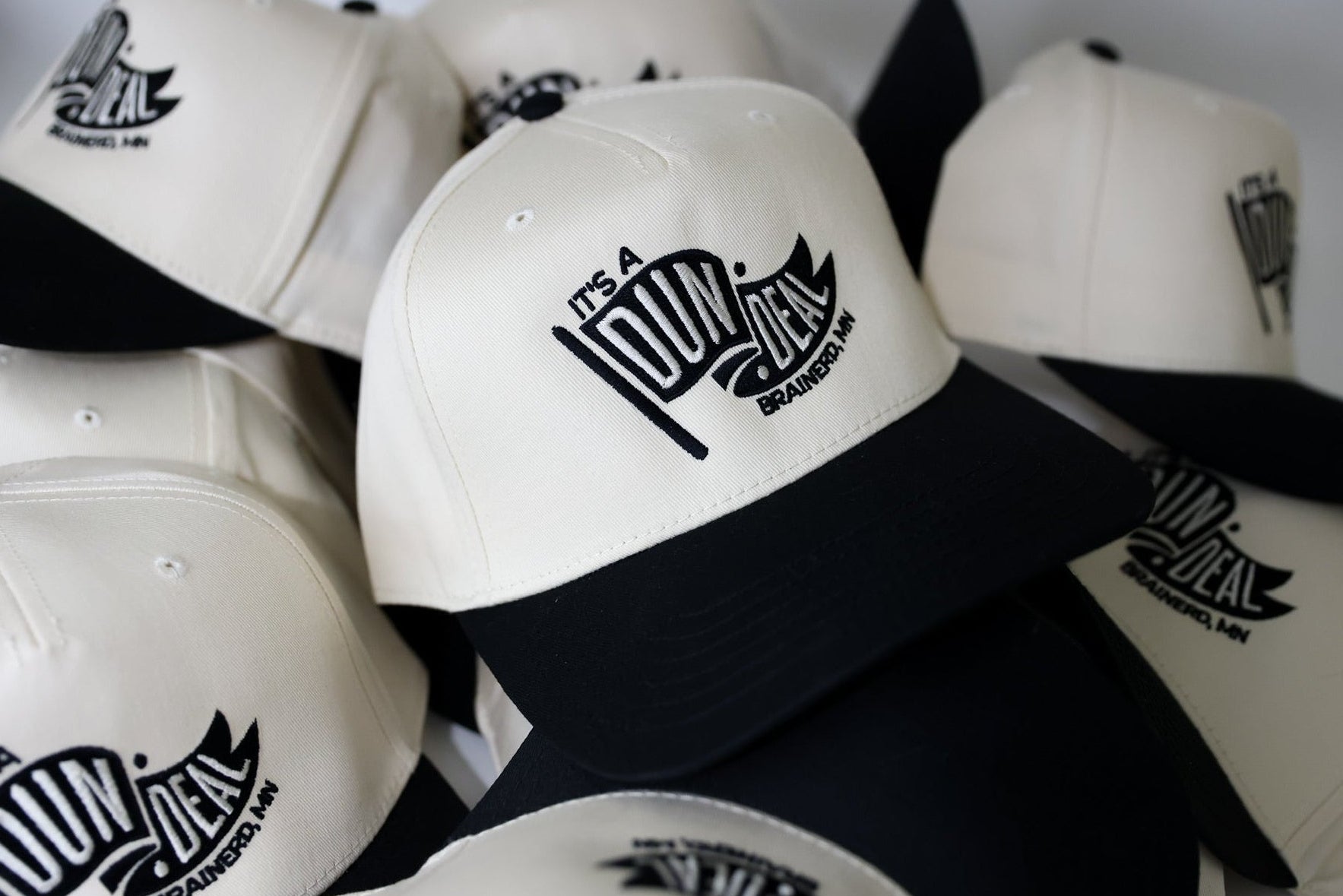 White caps with black brims and logos on a white background. Custom embroidered wedding hat. 