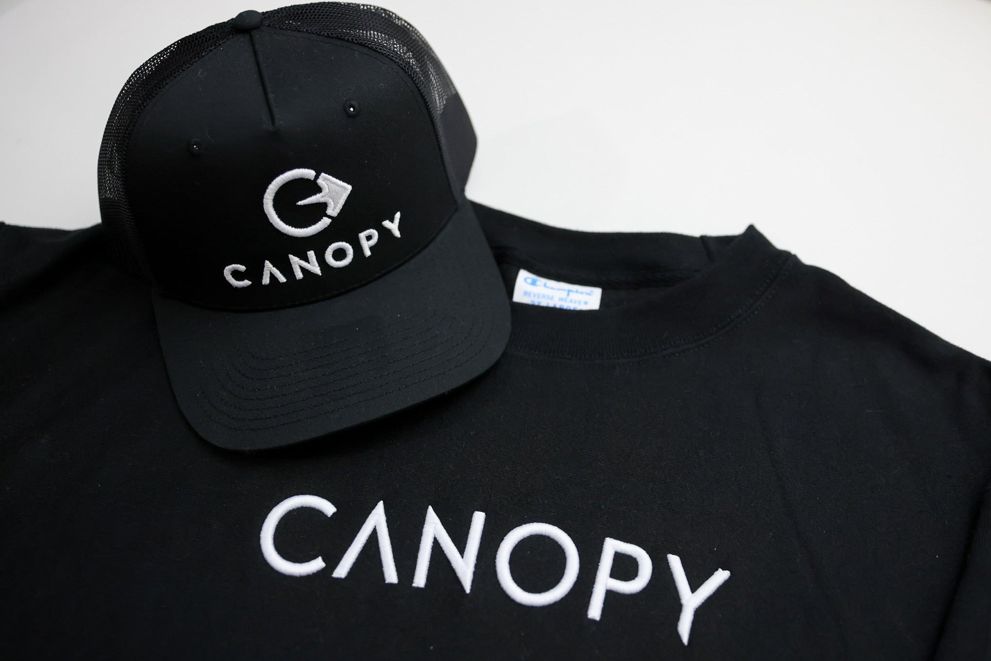 Black cap and sweatshirt with 'CANOPY' embroidered branding on a white background