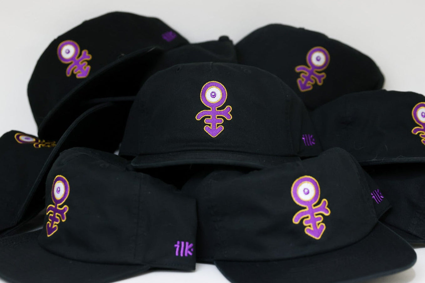 Black caps with purple and white designs on a white background