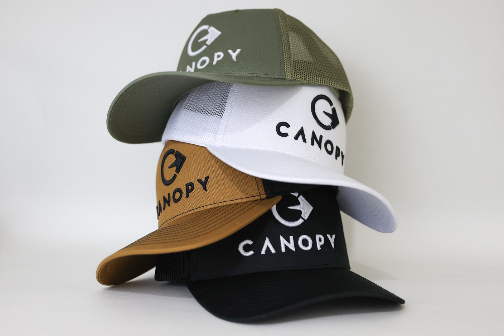 Four baseball caps in different colors with 'Canopy' branding on a white background. embroidered custom hats.