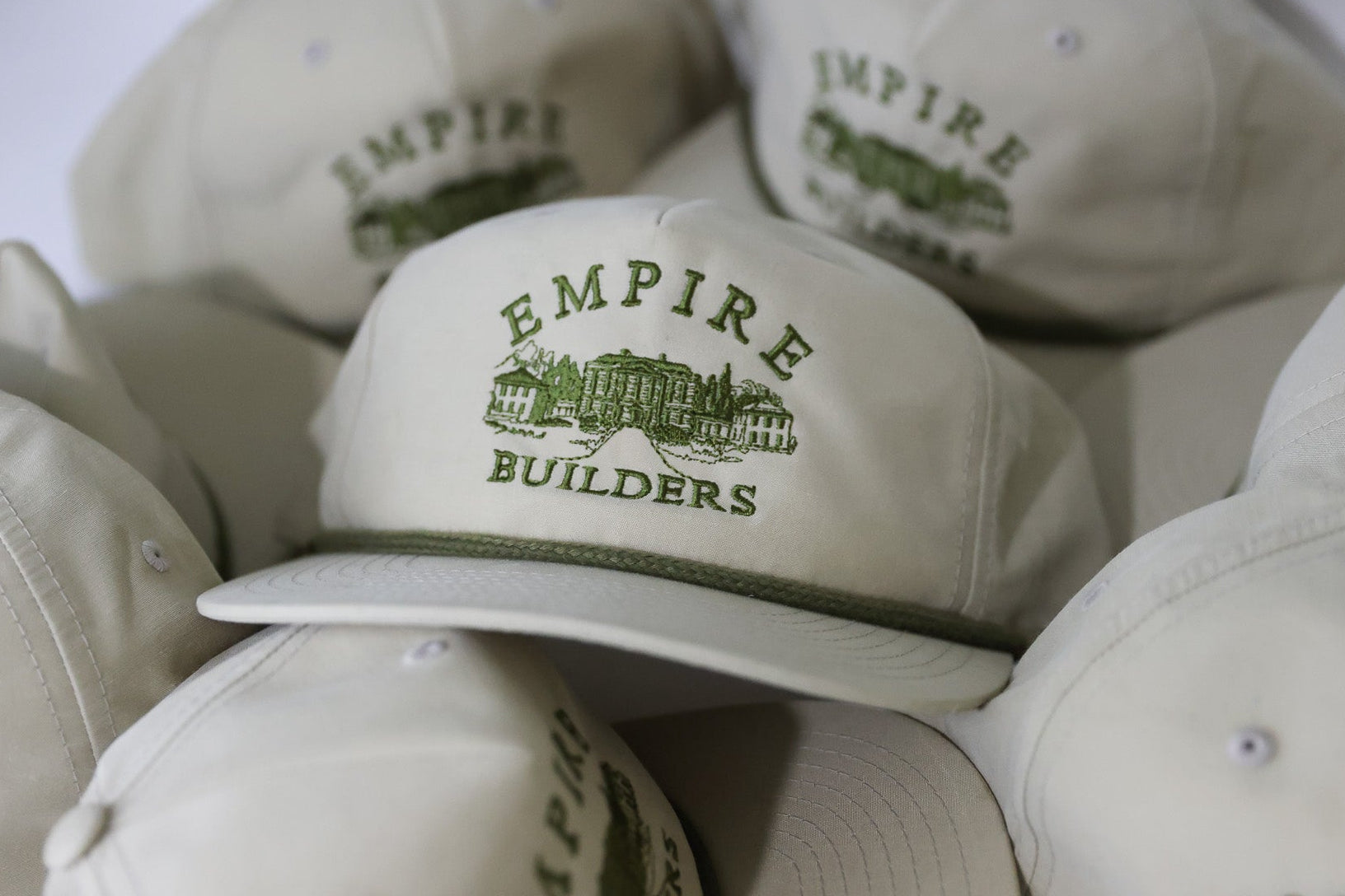 Beige caps with 'Empire Builders' logo on a white background embroidered custom hat