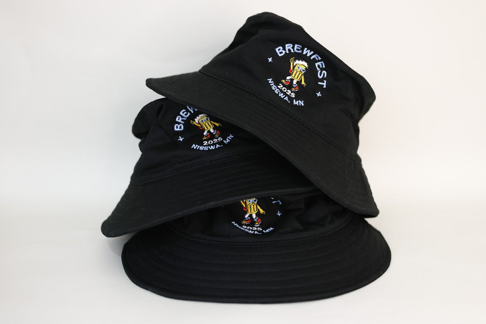 Stack of black bucket hats embroidered with a logo on a white background